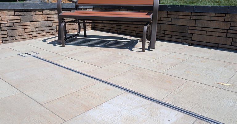 Pool deck with patio pavers with with slot drain with integrated reversible pan lid.